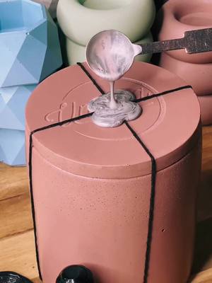 A post by @umbraapothecary on TikTok caption: Adding our wax seal to our plum candle! Peep our upcoming tea lights  in the back #candletok #candlebusiness #candlemaking #waxseal #waxstamp