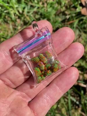 A post by @cannabisarcade on TikTok caption: @glasskid custom Mini Kinetic Nug Baggie Pendant 🔥 #glasspendant #glassart #handmade #glasskid