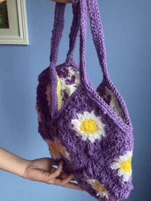 A post by @tootalzbkvvpz on TikTok caption: Purple daisy granny square bag.#crochet #crochetersoftiktok #crochetbags #crochettutorial #crochetbagtutorial