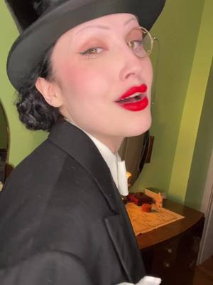 A post by @steffi_kay on TikTok caption: In an authentic 1920s mens suit in a 1920s apartment with 1930 Art Deco furniture. Almost 🤷🏻‍♀️