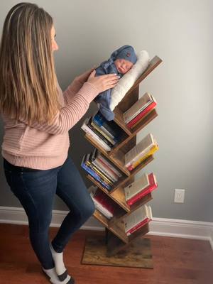 A post by @photographybyasiya on TikTok caption: #Newborn #NewbornPhotoShoot #BabyOnABookshelf #Bookshelf #BabyPhotography #NYCPhotographer #NJPhotographer #NewJersey #NewYork #Manhattan #PhotoShoot #Photos #NewbornPhotography #NewMom #baby