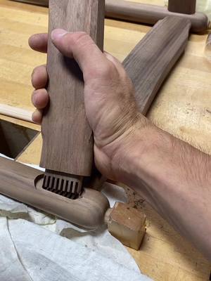 A post by @designedwithpurpose on TikTok caption: Working on a new dining chair design. I wanted to share this fun joint. I’m calling it a housed angled fingerjointed floating tenon. Using this to add strenghth back into the leg and seat rail. Plugs peotect grain during turning. #designedwithpurpose #woodtok #walnut #baltimore #woodworking #satisfying #artistsoftiktok #joinery