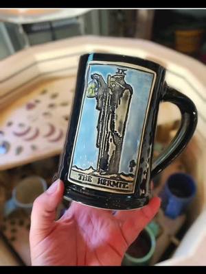 A post by @dirtworks_ceramics on TikTok caption: Mystery tarot mugs available for preorder now! Link in bio. #tarot #seasonofthewitch #tarotcards #witchtok #thehermit #thelovers #tarotok