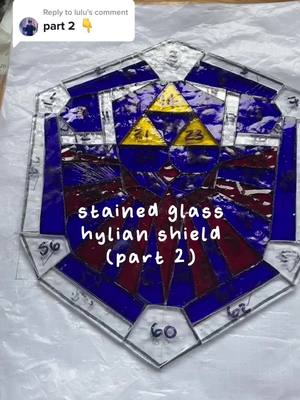 A post by @luluhrvy on TikTok caption: Replying to @lulu accidentally made the tip wonky but !!! my biggest & most complicated piece yet :) #stainedglass #glassart #GenshinTeleport #stainedglassart #UnlimitedHPInk #zelda #zeldabotw #botw #LoZ #art #artist #artistsoftiktok #legendofzelda #hylian #hylianshield #nintendo #nintendoswitch #gamer #game 