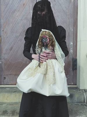 A post by @virtuouscourtesan on TikTok caption: Since you all told me this antique dress looked like a resident evil character —- i decided to bring #donnabeneviento to life with her doll angie.   I sculpted the dolls face, arms, and made her dress.  I did not make my dress (its an orignal victorian piece in my colelction) .  Donna’s veil changed to lace by design.  #re8 #residentevil #halloweene2022 #fyp #costume #cosplay #costumedesign #sew #lace #doll 