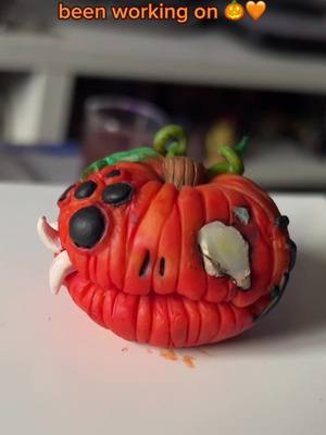 A post by @colourlesseyes on TikTok caption: In the midst of doing inktober have this W.I.P! Thinking about doing a limited run of these for October to see if I want to add them permanently to my shop… thoughts? 🎃🧡 #art #artist #clay #clayart #halloween #halloweeniscoming #halloweenishere #pumpkin #pumkinseason #clayartist #wip #claypumpkin #inktober 