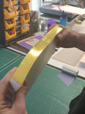 A post by @walkerprintltd on TikTok caption: Machine assisted edge gilding ✨ our bookbinders traditionally preparing a book block using coptic sewing for a trail piece, prior to casing in #asmr #bookbindersoftiktok #asmrsounds #asmrvideo #oddlysatisfying #BookTok #bookbinder #mastercraftsman #satisfying #goldleaf 