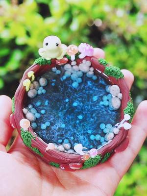 A post by @hopienoellecharms on TikTok caption: Froggy pond ^-^ 💚🐸 #claytok #clayartist #polymerclay #frog #frogtok #handmade #DIY #aesthetic #cottagecore #fairycore #jewelrybusiness #hopienoellecharms