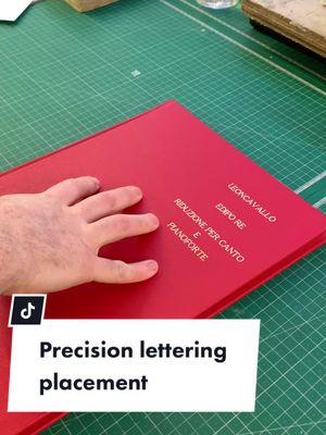 A post by @walkerprintltd on TikTok caption: Precision lettering with non-standard placement. This client requested a custom placement of lettering on their binding;  our bookbinders carried out several calculations to calibrate our lettering machine to the exact specifications. #asmr #oddlysatisfying #asmrvideo #asmrsound #oddlysatisfyingvideo #lettering #bookbindersoftiktok #bookbinder #fyp 