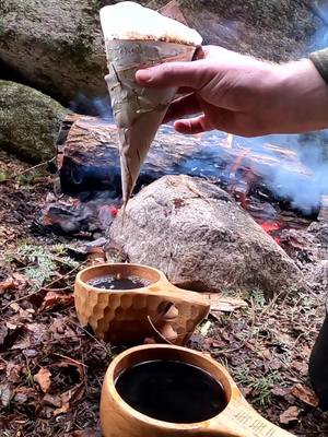 A post by @ted.baird on TikTok caption: Join us for a cup of Moose Call Mocha ☕️ Made with a Birch Bark Coffee Funnel 😎 @Heather Baird  #coffee #mocha #bushcrafting  #camping #wintercamping  #wildcamping  #overthefirecooking  #DIY  #crafts 