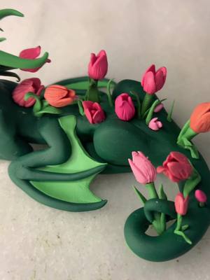 A post by @shipwreckedsketches on TikTok caption: More springtime dragons? Sure! This time its a tulip dragon. And yes I made the tulips myself :) #dragon #clay #polymerclay #claydragon #clayart #dragonart #tulipdragon #tulip #spring