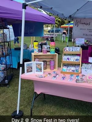 A post by @winnieswonderscreations on TikTok caption: Our day 2 set up! So proud of our first event! #vendorfair #craftfair #vendorbooth #Snowfest #glitterpens #glittertumblers #glittershears #badgereels