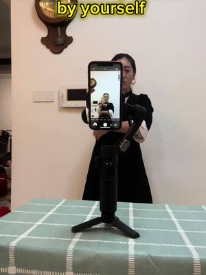 A post by @dianazjl on TikTok caption: 🤣🤣😆😆do you have the experience take photos by hand motions?let try#phone holder#stabilizer 