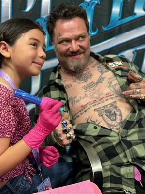 A post by @athenalynnink on TikTok caption: Watch out world, 9-year-old Athena Lynn Ink just made tattoo history by  tattooing “ Phoenix The Wolf”, his sons name ❤️ in her writing on the legendary Bam Margera at Kadabracon Expo in Corpus Christi! What an honor! 🎨✨ #InkProdigy #TattooLegend ##tattoos #tattoo #youngesttattooartist #niteowltattoostudio #kidsoftiktok #tattoojourney #kidhustle #kidswithbigdreams #kadabracon2024 #kidsgoviral #viralvideo #viral #memories #bammargera 