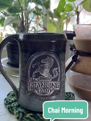 A post by @the.long.rest on TikTok caption: Easing my way into a busy weekend. A local Ren Faire, a D&D game, and the premier of House of the Dragon.  Hobbit Door Planter by @Maker_Bakery  Prancing Pony Mug by @GenX Potter  Coaster and Chai made by me. #lazymorning #geekydecor #masalachai #morningroutine #thelongrest 