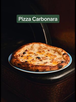 A post by @pipernopizza on TikTok caption: CARBO FEVER ! ❤️‍🔥 L’iconique recette de carbonara twistée sur une pizza : mozzarella fior di latte, pecorino romano, guanciale grillé, jaune d’oeuf et poivre noir du moulin ! À tester d’urgence ! #piperno #distagione #pipernoautomne #pizzalovers #autumnvibes #carbonara