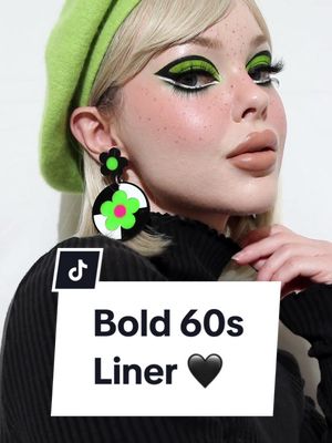 A post by @beatsbylizzie on TikTok caption: Bold 60s liner to match these beautiful earrings 💚💚💚 #60smakeup #60smakeuplook #greenmakeup #eddiesedgwick #twiggymakeup 