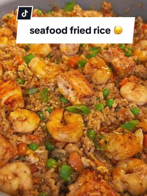 A post by @dineinwithdenise on TikTok caption: Seafood Fried Rice topped with a spicy cajun garlic butter sauce!! This was very big back but soooooo good 🙂‍↕️😆🤤 #friedrice #seafoodfriedrice #Foodie #salmon #shrimp #foodtiktok #dallaschef #shrimpfriedrice #fyp 