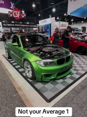 A post by @trinituner93 on TikTok caption: Check out this right hand drive BMW 1 series with a V8 M3 S65 engine! Here at Sema Car Show in Las Vegas. @SEMA Show  Comment if you want to see more cars from the show.  #fyp #foryou #viral #cars #carsoftiktok #lasvegas #sema #semashow #bmw #1m #v8 #rhd #carshow 