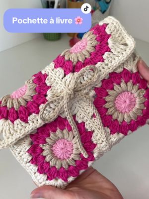 A post by @hellohanae on TikTok caption: Qui va crocheter ses cadeaux pour Noël ? 🎄  Pour une première idée je vous propose la pochette à livre au crochet 🌸 et dites moi si vous voulez un tuto !✨ #crochet #crochetersoftiktok #crochetgift #cadeauxdenoël #pochettealivre #christmascrochet #booksleeve 