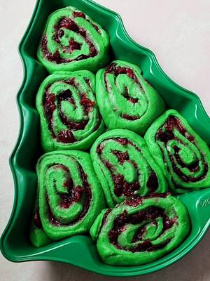 A post by @sashacakeschicago on TikTok caption: Cranberry Christmas Rolls Tree 🎄 Follow @sashacakeschicago for more recipes and tutorials!  For yeast dough: 1/2 cup (125 g) milk 4 tbsp (56 g) unsalted butter 1/4 cup (50 g) granulated sugar 2 cups (250 g) all-purpose flour 1 tsp active yeast 1/4 tsp salt 1 egg, room temperature green food color (optional) For the cranberry filling: 2 cups fresh or frozen cranberries 1/2 cup (100 g) granulated sugar 1 tsp cinnamon For the frosting: 4 oz (1/2 package, 113 g) cream cheese, softened 4 tbsp (1/2 stick, ~56 g) unsalted butter, softened 1 tsp vanilla 1/8 tsp salt 2/3 cup (65 g) powdered sugar christmas tree baking pan baking spray sprinkles (optional) Add milk, butter, and sugar to a small pot; mix and warm up over medium heat just until butter melts. Add the flour, yeast, salt, egg and green food color into a standing mixer’s bowl. Mix on lowest speed with hook attachment just until combined. Pour in the melted butter/milk/sugar mixture in a slow thin stream while the mixer is going on low speed. Increase the speed to medium-high and knead for 10 minutes. Warm up the oven to 200F, then turn it off. Transfer the dough into a separate greased bowl; cover with kitchen plastic and allow to rise in the warm oven for 1.5 hours. To make the filling: combine the cranberries, sugar and cinnamon in a medium saucepan and cook over medium heat for 10 minutes. Allow to cool before use. To make the frosting: whip the cream cheese and butter in a stand mixer fitted with the paddle attachment, 5 min. Reduce the mixer's speed to lowest and add vanilla, salt, and powdered sugar. Mix until combined. Once the dough has risen, roll it to a 1/4" thick rectangle. Spread the filling. Starting from the shorter end, roll the dough into a tight log. Slice into 1" pieces using a thread and tightly arrange in a greased pan; cover with plastic, and place into warm oven for 30 minutes to rise. Bake on 350F on middle rack for 15-18 minutes. Spread the cream cheese frosting while the rolls are still warm. Enjoy!🎄 . . . . #christmasdessert #breakfastroll #breakfastbunns #cinnamonrolls #cinnamonbuns #christmastreecake #christmascake #bakefromscratch #bakelove #baking 