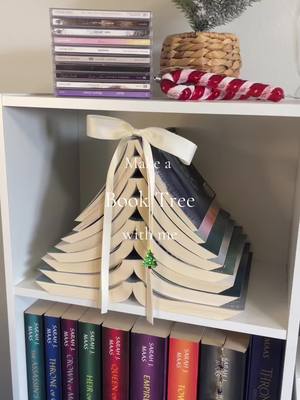 A post by @ilbooksttmats on TikTok caption: Book Tree!🎄(Their spines are okay, don’t worry) #booktree #bookmas #christmasbooks #merrychristmas #ilbooksttmats #bookmastree #ilovebooks 