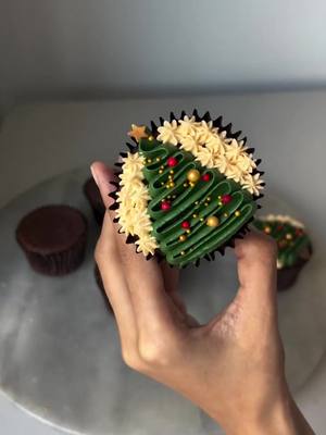 A post by @ennahs.cakes on TikTok caption: christmas tree cupcake🎄 #fyp #christmas #christmasbaking #cake #cupcake #christmascupcake #cakeart #cakevideo #christmastiktok 