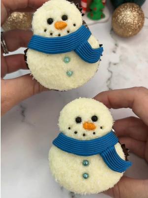 A post by @cakedbyrach on TikTok caption: FROSTY ☃️ ☃️ Day 21 of 24 days of Christmas treats 🎅🏼🧁🍪  Shaping cupcakes using piping tips #bakinghacks ☃️Fill your liners half full. ☃️Use small piping tips to shape before baking. Bake and cool. ☃️ Use a round piping tip to add  buttercream in the shape of a snowman.  ☃️ Press into desiccated coconut.. ☃️ Add sprinkles for the eyes and smile and an orange carrot sprinkle for the nose. ☃️ I used piping tip 48 to add a scarf. #cupcake #cakedecorating #snowman #cutecupcakes #cakedbyrach #shapedcupcakes #christmascountdown #christmastiktok 