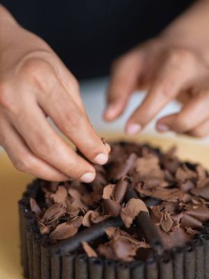 A post by @wildcookbook on TikTok caption: Christmas special chocolate cake 🍫✨ with Munchee Black Edition—Kalo and Rollz!  #wildcookbook #munchee #muncheeblackedition #kalo #rollz 