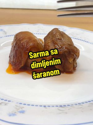 A post by @__kacolina on TikTok caption: ✨Sarma sa dimljenim šaranom✨ Za sve vas koji niste videli ovaj receptić prošle godine, evo ga receptić opet. 🤤 Sastojci: - Dimljeni šaran 3kg - Crni luk 5kg - Šargarepa 1.5kg - Beli luk po ukusu - Pirinač 500gr - Začini (so, biber, aleva paprika, tucana ljuta paprika, peršun, lovorov list) - Ulje oko pola litre - Kiseli kupus 1. Dimljenu ribu prokuvati dok ne omekša pa je i otrebiti od kostiju i kožure. (Sačuvajte kožuru) 2. Lukove, šargarepu iseckati i propržiti na ulju dok ne zacakli. 3. Ubacite otrebljenu ribu, pirinač i začine. 4. Kada se pirinač malko proprži punjenje za sarmu je gotovo. 5. Kiseli kupus potopite malo u vodu ako je previše slan ili kiseo. Odvojiti liske i obraditi kao na snimku. 6. Ostatak procesa se vidi. Na kraju sam sipala pola litre vode (dovoljno da prekrije sarmu) i zapršku preko sarme. (Na ulju sam propržila malo aleve paprike, samo dok nije zamirisala) Pekla sam u rerni poklopljeno na 220 dok nije provrila pa smanjila na 150 neka 4h.  *Ovo je mera za oko 130 sarmi, a u ovaj sač je stalo nekih 60komada, mere prilagodite vašim potrebama. Prijatno! 💁🏻‍♀️🥰 #kacolina #sarma #posnasarma #riba #posnirecepti #Recipe #recept #EasyRecipe #ispodsaca #fish #balkanfood #balkantiktok #balkanviral #christmasdinner #DinnerIdeas 