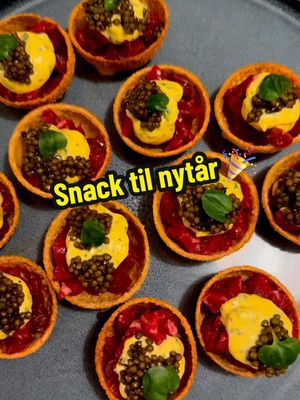 A post by @pissegodmad on TikTok caption: Snack til nytår🎉 | Det hele kan forberedes på forhånd😍 | Opskrift 👇🏻  Opskrift 10 personer  Tid: 1 time  Sværhed: nem  10 Pani Puri skaller(købes hos Gourmet Engros online, eller hos en gade bazar eller grønthandler) hvis man bor i Aalborg kan man hente et par skaller hos mig i Aalborg inden nytår 😂😂  400 g oksemørbrad  Olivenolie  Salt  400 g mayonnaise(køb hellmanns)  1 helt bundt frisk estragon  1 knivspids gurkemeje  1 potte frisk brændkarse(kan købes hos Føtex)  60 g antonius caviar (kan købes online)  1 citron  Start med at fritere dine pani puri skaller. De skal kun have 30 sekunder. Olien skal være mellem varm. Sørg for at vende dem i olien konstant så de får den samme farve på begge skaller. Skær forsigtigt igennem skallerne med en brødkniv der hvor samlingen er.  Bland din mayonnaise med helt fint hakket estragon, gurkemeje og 1 knivspids salt. Smag til med citronsaft.  Frys din oksemørbrad ned. Skær den i fine brunoise stykker. Kom olivenolie og salt henover. Bland rundt. Og kom i en lufttæt beholder til det skal bruges.  Placer skaller på en lille dut mayonnaise, eller i en skål med hestebønner så de står fast. Bønner er bedst, da skallerne bliver bløde i bunden hvis de står i mayonnaise for længe.  Andet med tartar, mayonnaise, caviar og brøndkarse.  Godt nytår! 😍🎉 #nytår #nytårsmad #inspiration #mad #food #fyp #opskrifter #nam #madlavning #nemt #nemmad #viral #snack 