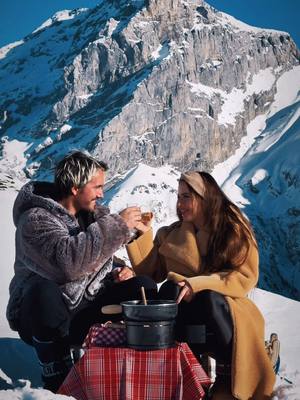 A post by @swiss_beautiful on TikTok caption: Preparing her a fondue picnic in the Alps🏔️ What a magical moment! ❤️#switzerland #CoupleGoals #fondue #mountain #coupleideas @Engelberg.Titlis 