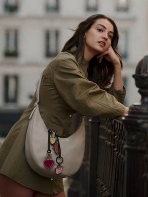 A post by @longchamp on TikTok caption: From coffee to conquering Paris. The Essential's got her covered. Collection: #LongchampSS25 #LongchampSS25 #longchampbag #essential #ootd #fashion #parisianstyle