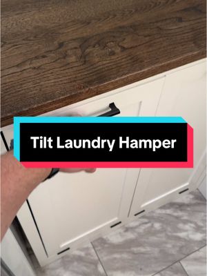 A post by @stayathomewoodworks on TikTok caption: What do you think of this laundry hamper tilt cabinet? #laundryroom #cabinet #woodworking #woodwork #laundryroomideas #laundryroomstorage #storage #customwoodwork 