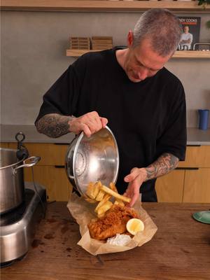 A post by @andy_cooks on TikTok caption: Fish and Chips with Tartar Sauce This recipe features a simple version of Heston Blumenthal's famous beer batter and his renowned method for triple-cooked chips, which has become a staple in restaurants worldwide. Ingredients Fish and chips - 4 x 200g (7oz) portions of white fish suitable for frying (e.g., hake, snapper, flathead, or blue grenadier) - 8 large potatoes suitable for chips (e.g., Sebago, Russet Burbank, King Edward, Dutch Cream, Maris Piper, or Kennebec) - lemon wedges - scrunched parchment paper (optional) Tartar sauce: - 200g (7oz) mayonnaise - zest of 1 lemon - 3 shallots, finely diced - 8 cornichons, finely diced - 3 tbsp (45ml) baby capers, roughly chopped - small bunch of fresh dill, finely chopped Frying and batter: - 4 litres (7 pints) oil for frying (peanut oil or tallow work well) - 200g (7oz) plain flour, plus extra for dusting - 200g (7oz) white rice flour - 1 tsp baking powder - 1 tbsp (15ml) honey - 300ml (10 fl oz) vodka - 300ml (10 fl oz) lager or any light beer - salt and white pepper Method Prepare the Chips - Peel the potatoes, rinse thoroughly, and cut into thick chips, about 2cm (¾ inch) square. - Place the chips in a bowl of cold water and soak for 10–15 minutes to remove excess starch. - Rinse the chips under fresh water, then add them to a large pot. Cover with cold water, add a large pinch of salt, and bring to a simmer. - Cook until the chips are soft and nearly falling apart. - Remove carefully and place on a wire rack over a tray. Refrigerate until completely cool. Make the Tartar Sauce - In a small bowl, combine the mayonnaise, lemon zest, diced shallots, dill, cornichons, and capers. - Mix thoroughly, cover, and refrigerate until needed. First Fry of the Chips - Heat the oil in a deep fryer or large pot to 140°C (285°F). - Fry the cooled chips in batches for 6–7 minutes until the outside is set but not coloured. - Remove from the oil and drain on paper towels. Set aside to cool. Make the Batter - In a large bowl, whisk together the plain flour, rice flour, and baking powder. - Gradually add the lager, vodka, honey, and a pinch of salt, whisking until the batter is smooth and has the consistency of pouring cream. - Chill in the fridge until ready to use. Cook the Fish - Heat the oil to 180°C (350°F). - Lightly season the fish fillets on both sides with salt. - Prepare a tray of seasoned flour (mixing salt and white pepper). Coat each fish fillet in the flour, shaking off any excess. Dip the fish into the batter, ensuring it is well coated. - Carefully lower the fish into the hot oil, holding it halfway in for a few seconds to help the batter set before fully submerging. - Fry the fish for 8–10 minutes until golden brown and crispy. - Remove to a wire rack to drain, season with salt, and keep warm in an oven set to 70°C (160°F) if cooking in batches. Second Fry of the Chips - With the oil still at 180°C (350°F), fry the chips again in batches for 8–10 minutes until golden and crispy. - Drain excess oil and season generously with salt. Serve - Arrange the fish on scrunched parchment paper for a traditional look. - Serve alongside the crispy chips, tartar sauce, and a wedge of lemon.