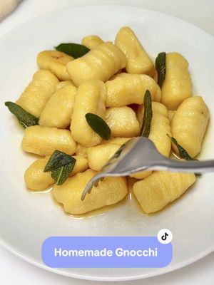 A post by @chefgenevieve on TikTok caption: Homemade Gnocchi Recipe. Just 3 ingredients—potatoes, egg yolk, and flour that come together for make soft, pillowy perfection. Full recipe below and on my blog! #HomemadeGnocchi #ComfortFood #HomemadeGnocchiRecipe #dinnerrecipes  Recipe: Serves 2-4 1 large or 2 small russet potatoes (need 300g or 2.5 cups after cooking/riced) 100g flour (or 2/3 cup) 1 egg yolk Salt Directions: Peel, dice, and boil potatoes in heavily salted water until fork tender. Pass potatoes through a ricer into a bowl. (You need 300g of cooked potato or 2.5 cups) While still warm, place potatoes on a lightly floured dusted work surface area. Make a dome in the center of the potatoes and add in the egg yolk in the center. Spread 100g (or 2/3 cup) of flour around the edges. Cut through the dough using a bench scraper or dough cutter until you have a crumbled consistency then use your hands too knead until just combined. Do not over-knead. Rest covered for 10 minutes.  Split dough into 4 sections. On a lightly floured work surface, roll each section into a log about 1 inch thick then cut into smaller sections (pillows). Keep on a floured dusted surface to prevent from sticking.  For grooves: If you prefers gnocchi with grooves, you can use the back a fork to roll the dough down on to creates the indents. (Place cut side down on fork tines, then using pressure, press dough down along the fork tines while rolling). Cook the dough: Working in batches, drop the gnocchi in simmering salted water. As soon as they float to the top, immediately remove with a slotted spoon and transfer to an oiled surface area.  Toss in your favorite sauce, sear with butter and sage or combine with pesto. Enjoy!