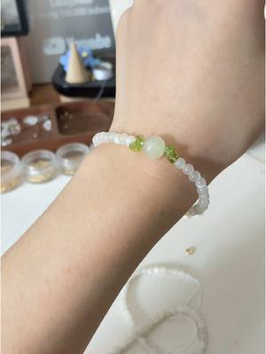 A post by @likayjewel_diylilylin on TikTok caption: Beads bracelet made of white moonstone, peridot and green calcite #handmadejewelry #bracelet #braceletmaking #bracelettutorial #beadsbracelets #moonstone #crystals #crystalbracelets #braceletlover 