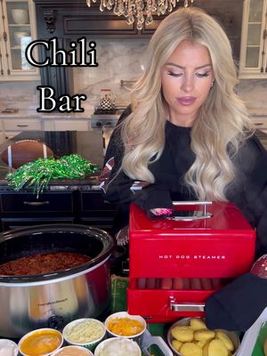 A post by @macy.blackwell on TikTok caption: Ultimate Chili Bar!🌭🏈 A crowd-pleasing game day spread! It’s all about the toppings!👏🏼 Enjoy a bowl of chili, chili dog, or both!  Everything is linked in my LTK and Amazon storefront!  Here’s what I used:  - crockpot full of chili  - Hot dogs & buns  - Colby jack cheese  - mozzarella/provolone  - nacho cheese  - diced onion  - sour cream  - avocados  - green onion  - cilantro  - Fritos  - tortilla chips  - crackers  - corn bread muffins - cinnamon rolls #gamedayfood #gamedayeats #superbowl2025  #superbowlparty 