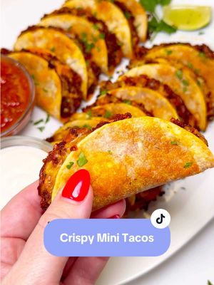 A post by @chefgenevieve on TikTok caption: Crispy Mini Tacos 🌮 Simple, crispy and delicious and perfect for game day!✨ #Tacos #GameDayRecipe #MiniTacos #CrispyMiniTacos Crispy Mini Tacos 🌮  Makes 12 Ingredients: 1lb meat of choice (you can use ground beef with taco seasoning, pork chorizo or shredded chicken) 12 street size corn tortillas 8oz Mexican shredded cheese  1 cup salsa 1 cup sour cream Cilantro for garnish Directions: Cook your meat of choice and set aside. Spray a foil lined sheet pan with oil then lay on your corn tortillas. Add meat and top with shredded cheese. Bake in a 425°F oven for 2 minutes until cheese has just melted. Fold tortillas in half and return to oven for 12 more minutes or until tortillas are crispy. Serve with salsa and sour cream. Garnish with cilantro. Enjoy!