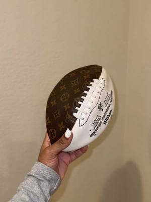 A post by @kjaejones on TikTok caption: Pharrell inspired me to think outside the bag – watch me transform this football into a LV football purse. 🏈 #footballpurse #louisvuitton #transformation #nflgameday #pharrellwilliams #parisfashionweek 