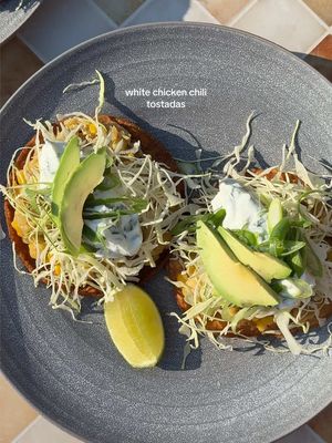 A post by @zoebarriesode on TikTok caption: white chicken chili, but make it ✨tostadas✨ (all details/recipe will be on Restaurant Dropout 1/31)!!!!  #dinner #recipes #ingredientprep 