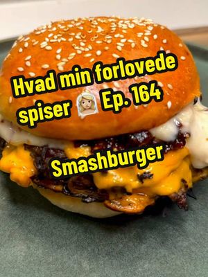 A post by @pissegodmad on TikTok caption: Hvad min forlovede spiser👰🏼‍♀️ | Episode 164 | Opskrift 👇🏻 Smashburger 😍👏🏻 Opskrift 2 personer  Tid: 1 time  Sværhed: let  Bøffer:  400 g oksekød  Salt  1 løg  4 skiver cheddar smelteost Solsikkeolie  Bacon hvidløg Mayonnaise:  200 g mayonnaise  100 g bacon  1 helt hvidløg  Olivenolie  Salt  2 spsk ahornsirup  Bacon chili jam:  200 g bacon  0,5 rød chili  0,5 grøn chili  2 skalotteløg  3 fed hvidløg  2 spsk brun farin  4 spsk ahornsirup  4 spsk hvidvinseddike  Olivenolie  2 burgerboller  1 rødløg  Syltede agurker  Start med at skære toppen af et helt hvidløg. Giv det salt og olivenolie. Pak det ind i sølvpapir. Bag det ved 190 grader varmluft sammen med 100 g bacon. Hvidløg skal bages ca. 40 min. Bacon til sprødt.  Hak skalotteløg og hvidløg fint. Skær chili og bacon i skiver. Steg bacon i lidt olivenolie. Tilsæt løg, hvidløg og chili. Svits 5 min. Tilsæt hvidvinseddike, sirup og brun farin. Lad det simre ved middel/lav varme til det er karamelliseret.  Form 4x bøffer af 70-80 g stk. giv dem salt. Riv et løg på et mandolinjern. Tryk løg ned i bøfferne. Smash bøfferne med løg siden nedad på en varm pande i lidt solsikkeolie. Når de er karamelliseret med stegeskorpe smeltes 2 skiver ost på hver. Stak dem oven på hinanden.  Steg bollerne let sprøde på panden.  Anret med bacon mayonnaise, rødløg, bøfferne, syltede agurker, bacon chili jam, mere mayonnaise og top på.  En halv er nok for det fleste, velbekomme! 👏🏻😍 #mad #aftensmad #aftensmadinspiration #inspiration #fyp #chefen #fypp #hund #kæledyr #sundmad #pissegodmad #food #opskrifter #nam #viral_video #burger #smashburger #meat #cheese 