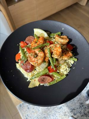 A post by @emmanuelduverneau on TikTok caption: Cajun Shrimp and Sausage Sheet Pan with Orzo Recipe: 1 lb large shrimp, peeled and deveined  olive oil Cajun seasoning Old Bay seasoning   1 spicy sausage link, sliced 3 cups green beans, cut in half 1 1/2 red bell peppers, chopped into chunks 1 yellow onion, chopped into chunks -Preheat oven to 400°F. Line a large sheet pan with parchment paper and add onion, bell pepper, green beans, and sausage. Add 2 Tbsp olive oil and 2 Tbsp Cajun seasoning. Mix until everything is evenly coated. Spread out vegetables and sausage evenly and cook for 16 minutes.  -In a bowl, add shrimp and mix with 1 tsp olive oil, 2 tsp Cajun seasoning, and 1 tsp Old Bay seasoning. Add shrimp to the sheet pan and cook for another 6 minutes until shrimp is fully cooked. Orzo: 1 lb orzo  1 cup frozen corn, thawed 2-3 Tbsp olive oil 1/4 cup basil, chopped 1/2 a lemon, squeezed salt to taste  -Add water to a medium saucepan. Salt and bring to a boil. Add orzo and cook until al dente. Drain. In the same saucepan over very low heat, add corn and orzo. Add olive oil, basil, lemon juice, and salt. Mix until fully incorporated. Enjoy! #EasyRecipes #healthyrecipes #food 