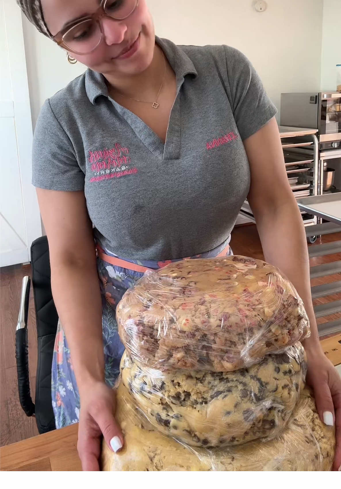 A post by @azucarmorenausa on TikTok caption: Hoy trabajé 4 sabores (120/124 galletas aproximadamente) Almond Joy/ Raffaello/ Chocolate Chip y Strawberry 🍪 #cookie #nycookies #cookiedough #makingcookies #galletas 