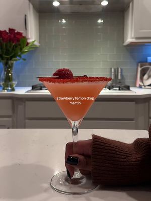 A post by @lexijxhnson on TikTok caption: Valentine’s Day Cocktails pt. 1: strawberry lemon drop martini- please bring this up to me while I’m doing my make up 😭🗣️  2-2.5 oz vodka (I do 3oz I like mine stronger) 1oz lemon juice (or 1 lemon) 1/4 oz simple syrup 1/2 oz Triple sec  1/2 oz Strawberry purée  For the strawberry purée: 1/2 cup water 1/4 cup sugar (1/2 cup if you like it sweeter) 1 cup strawberries  -boil until the sugar is dissolved -muddle, cover and takeoff the heat to cool then strain 