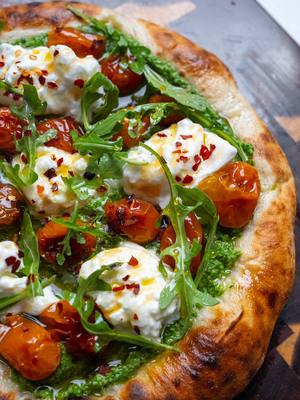 A post by @breadbakebeyond on TikTok caption: Burrata Caprese Pizza Whether it’s for the Super Bowl or Valentine’s Day, this Neapolitan-style Caprese pizza is a solid choice. Topped with fresh basil pesto, creamy burrata, and slow-roasted cherry tomato confit, then finished with a drizzle of hot honey for that perfect balance of flavors. I used a homemade Neapolitan-style dough in a pizza oven, but any pizza or focaccia will work. #superbowlfood #nycfoodie #hothoneypizza #neapolitanpizza #valentinesday #laeats #burrata  Super Bowl party food Burrata pizza recipe Game day eats Valentine’s Day dinner idea