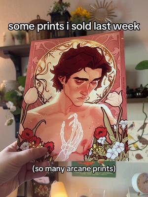 A post by @arcanegold on TikTok caption: just a lil round up of some of the art ill be sending out this week :> if you can click a few buttons or comment ur fav ice cream flavor or something it would rly help me out!!! bills are high HAHA #prints #wha #dragonage #jayvik #arcane #hadesgame 