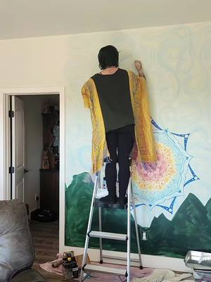 A post by @mavissky1 on TikTok caption: Shout out to my dad who now has a cooler wall than I do. Started this this weekend and got this much accomplished so far. The mountains and final details are gonna have to wait till my next visit haha  #wallmural #hussel #mandala #wallpainting #artist #fyp #houseproject 