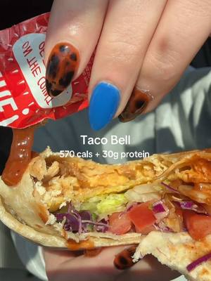 A post by @smallersam_pcos on TikTok caption: Taco Bell🌮💚 (570 cals + 30g protein) Here’s how to order:  -Crunch Wrap Supreme with cantina chicken instead of ground beef, extra chicken, no sour cream, add purple cabbage. (570 cals) extra fire sauce -Large Dirty Baja Blast Zero (60 cals)  or you could just get the regular Baja Blast Zero for 15 cals instead.  #fastfood #caloriedeficit #protein #menu #hack #tacobell #mealprep #fire #sauce #taco #real #mom #healthy #balance #togo #lunch #churros #order 