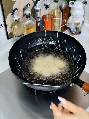 A post by @newlifehacks03 on TikTok caption: Have you ever seen such a convenient folding frying net? It is made of 304 stainless steel and has a portable design. It can be folded and used for frying. It can be put into the pot directly. It is easy to drain and not hot to the touch. It is easy to clean and will not rust after long-term use. It is a good helper in the home kitchen #FryingBasket